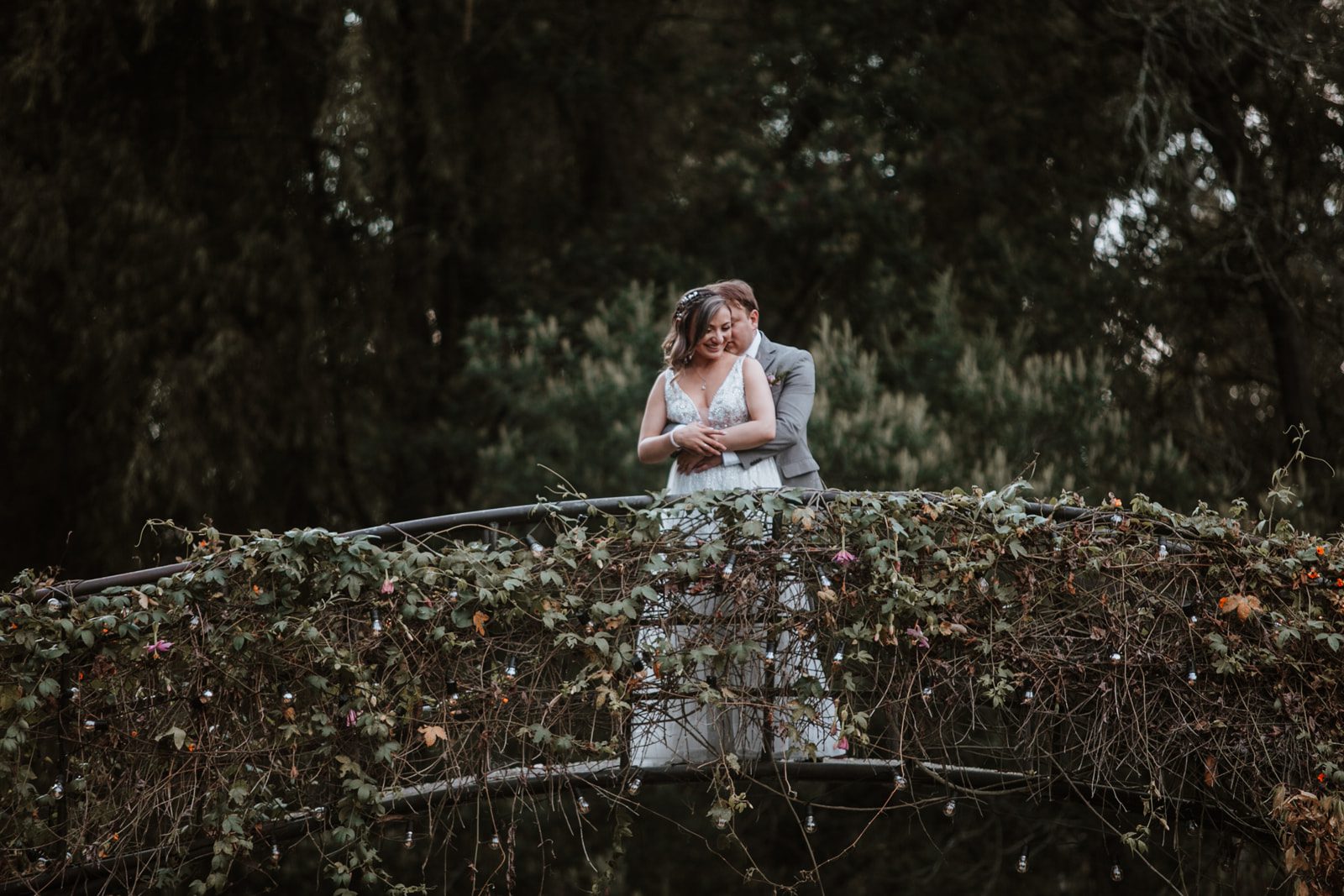 Novios posando en su matrimonio campestre rodeados de naturaleza.