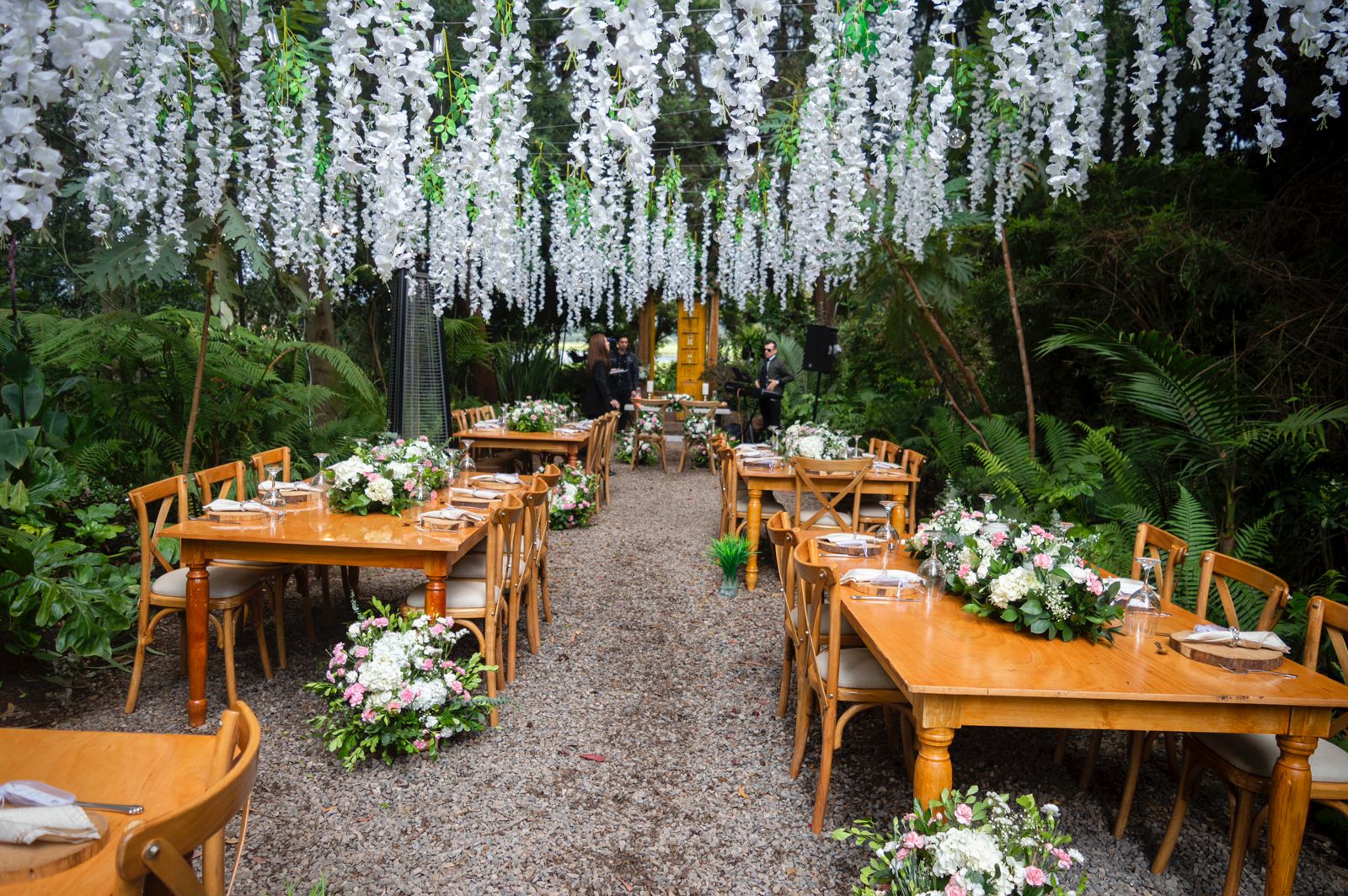 Mesas rectangulares de madera natural decoradas para boda campestre.