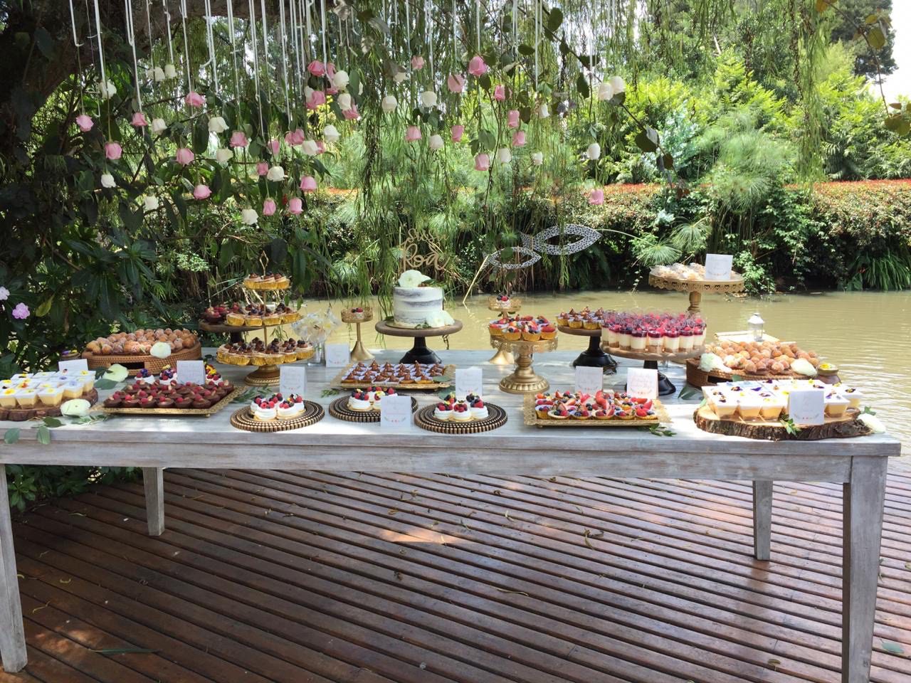 Mesa vintage para postres rectangular con hiedra artificial y troncos en Casa Aragón.