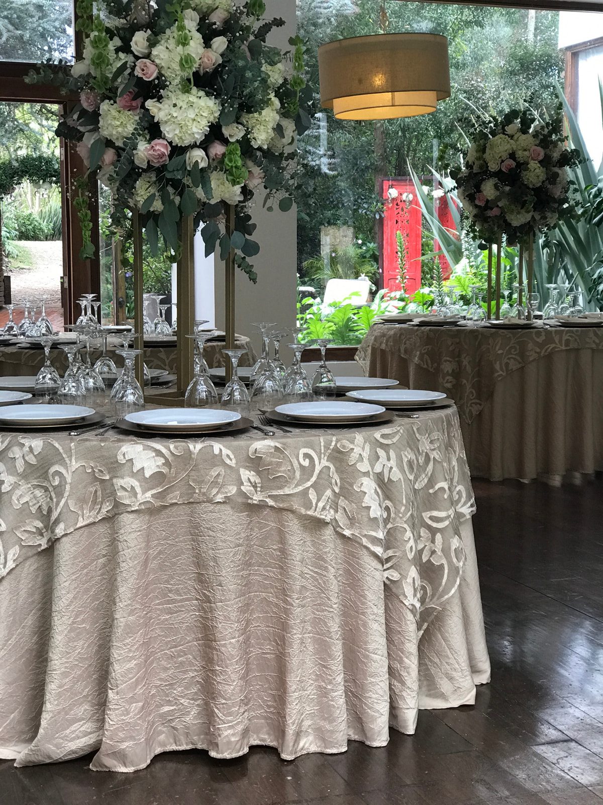 Mesas redondas de tablones en montaje de boda elegante.