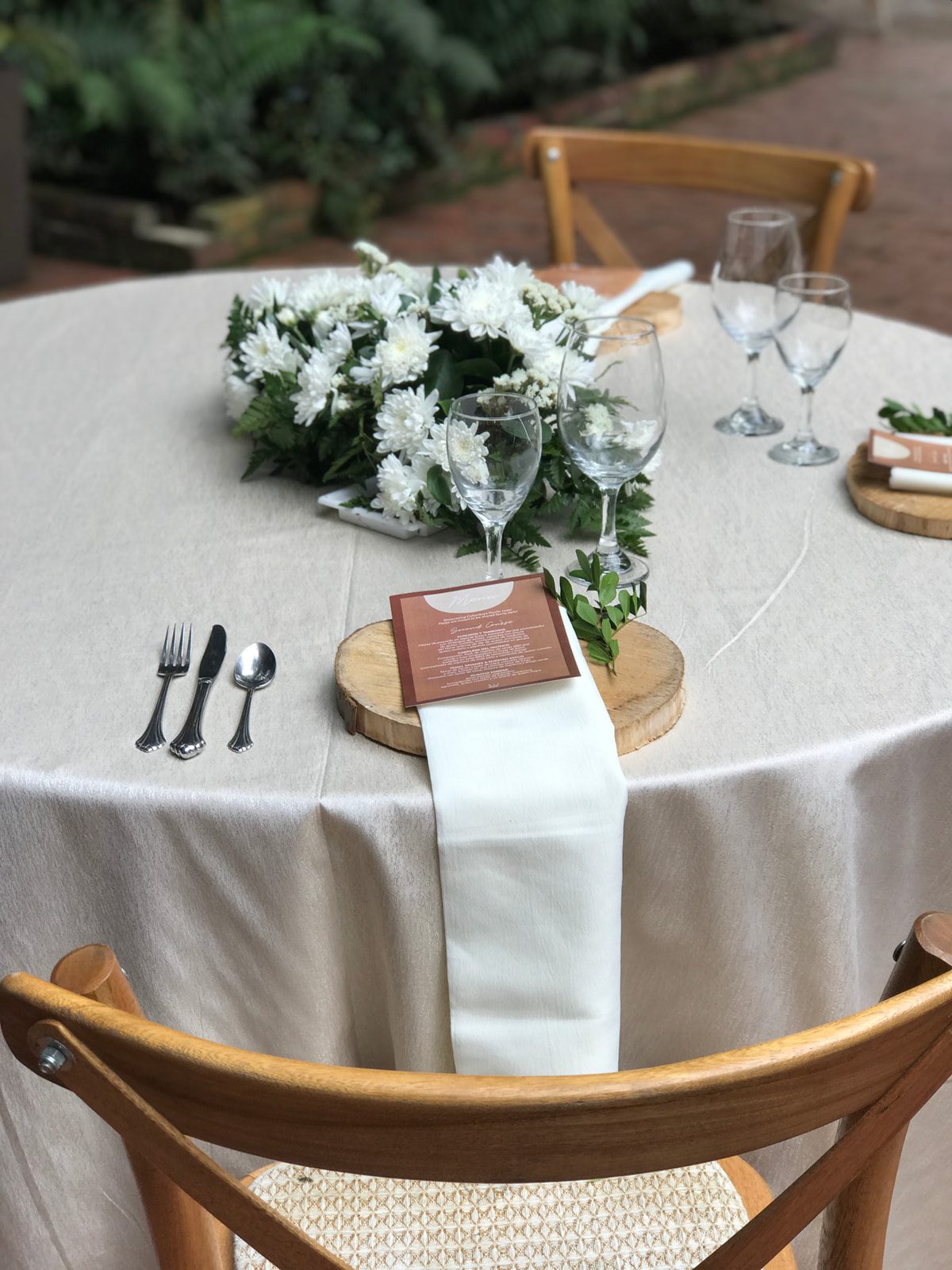Detalle de platos base de madera natural con vajilla blanca en Casa Aragón.