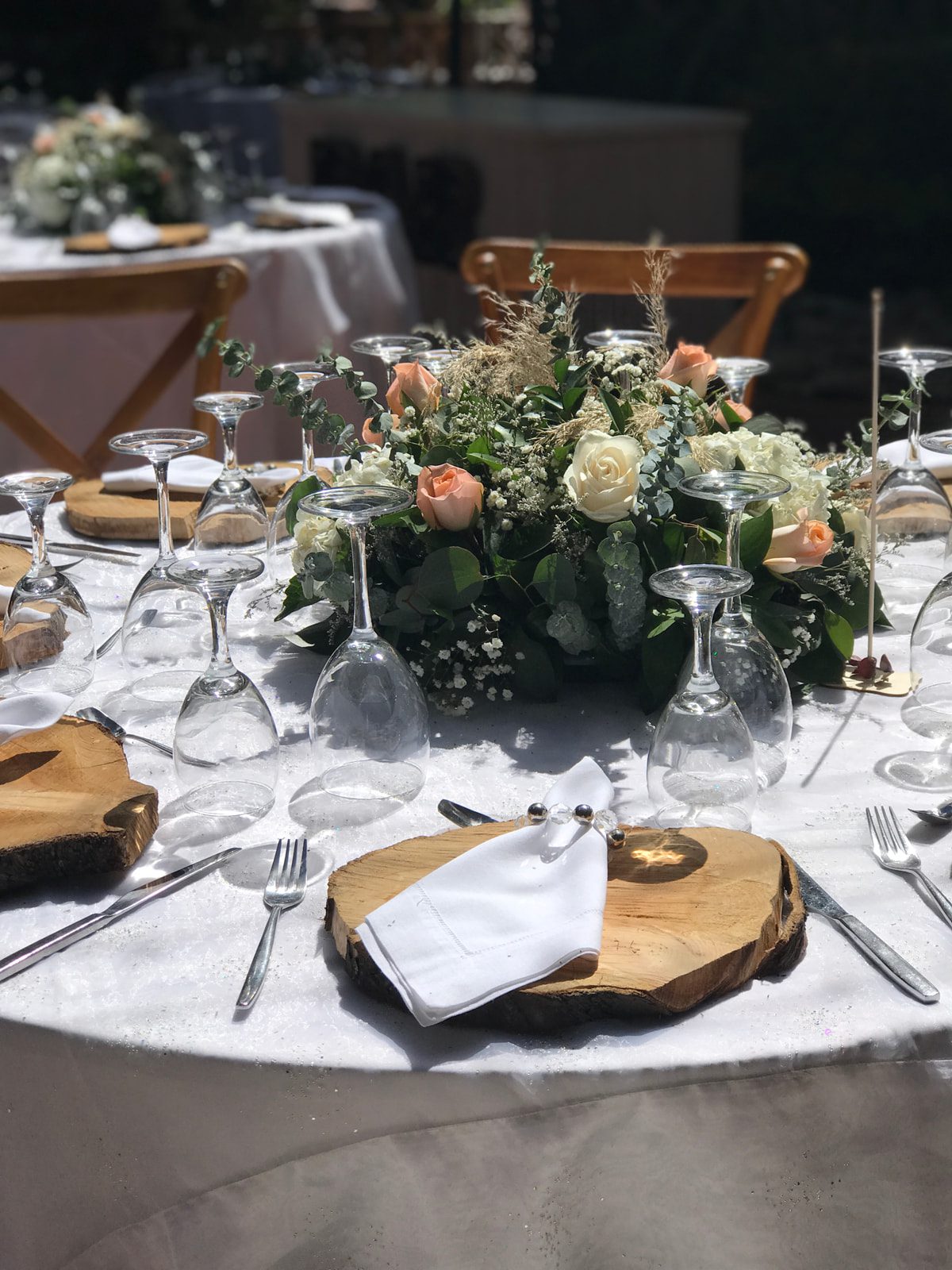 Platos base de troncos naturales en mesa de boda campestre en Casa Aragón.