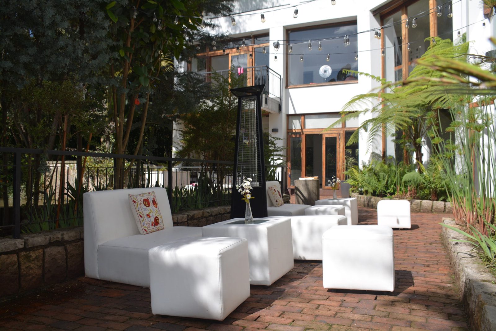 Sala lounge blanca decorada con flores y luces en boda romántica en Casa Aragón.