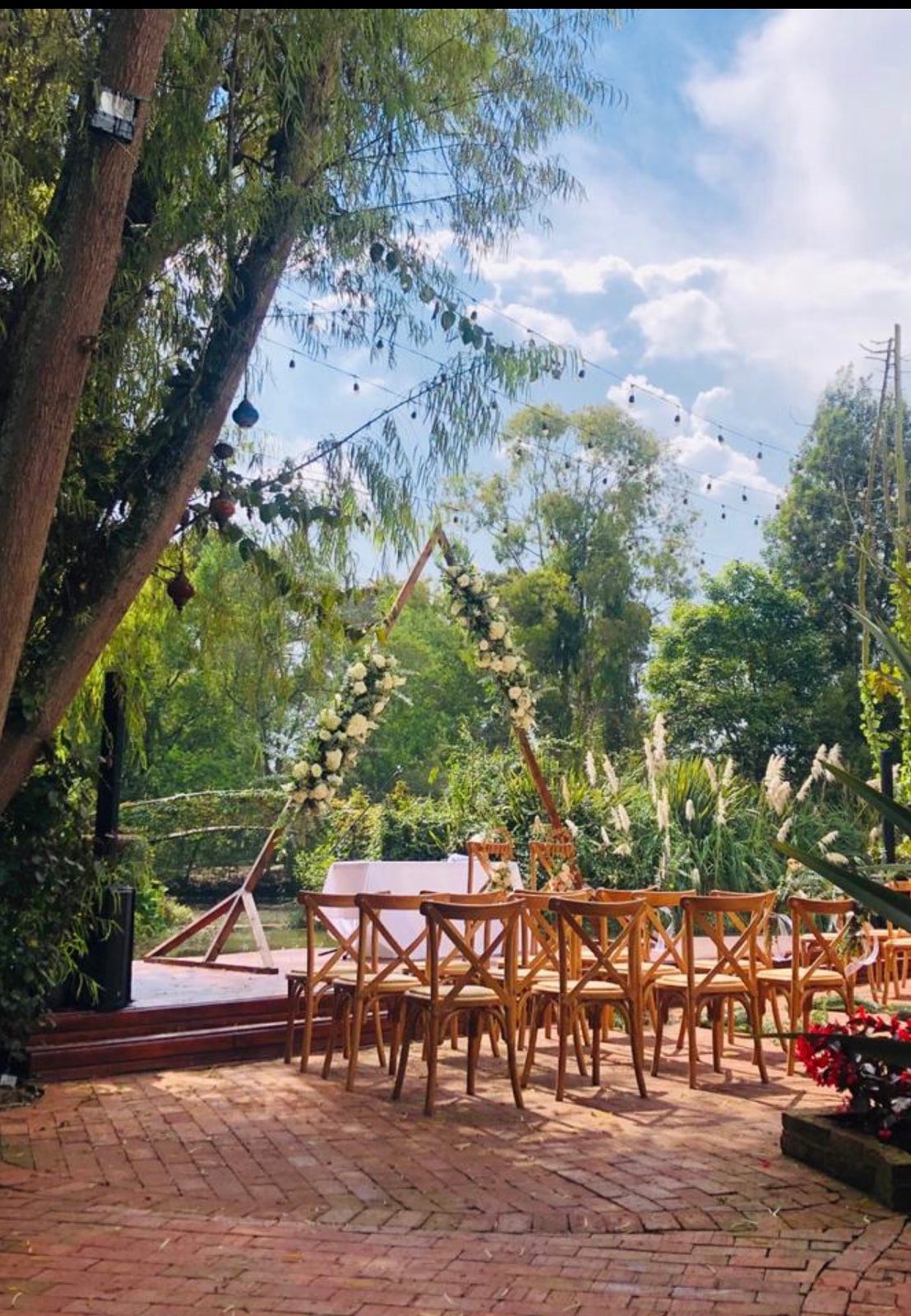 Sillas Crossback de madera natural decoradas con flores en matrimonio campestre en Casa Aragón.